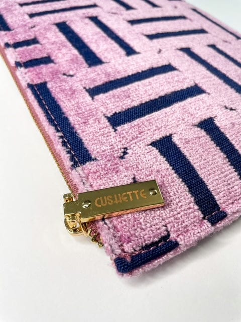 Closeup of zipper pull of pink and navy clutch handbag